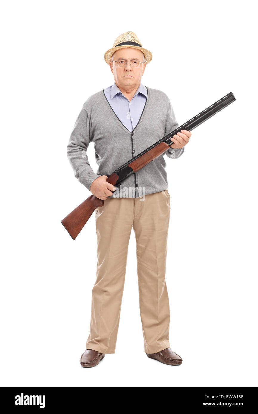 Full length portrait of a serious senior gentleman holding a shotgun and looking at the camera isolated on white background Stock Photo