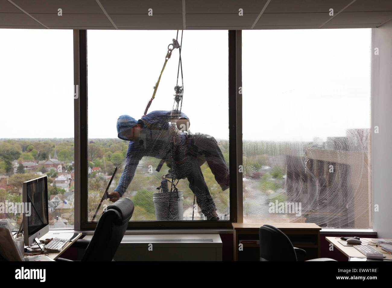 Window washer viewed from the inside of an office building, New Rochelle, NY, USA Stock Photo