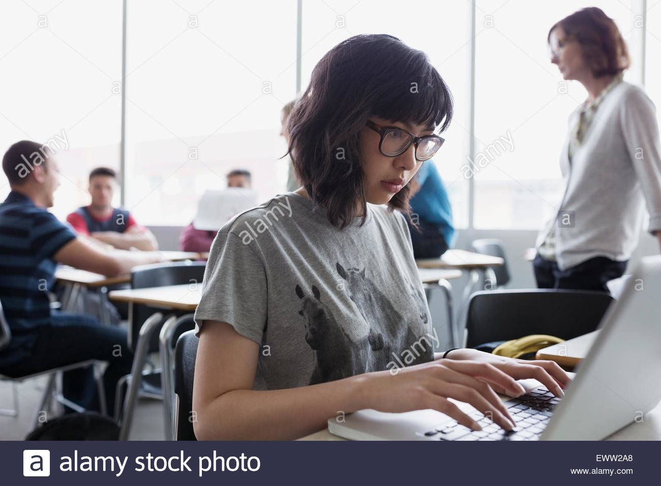College student typing at laptop in classroom Stock Photo