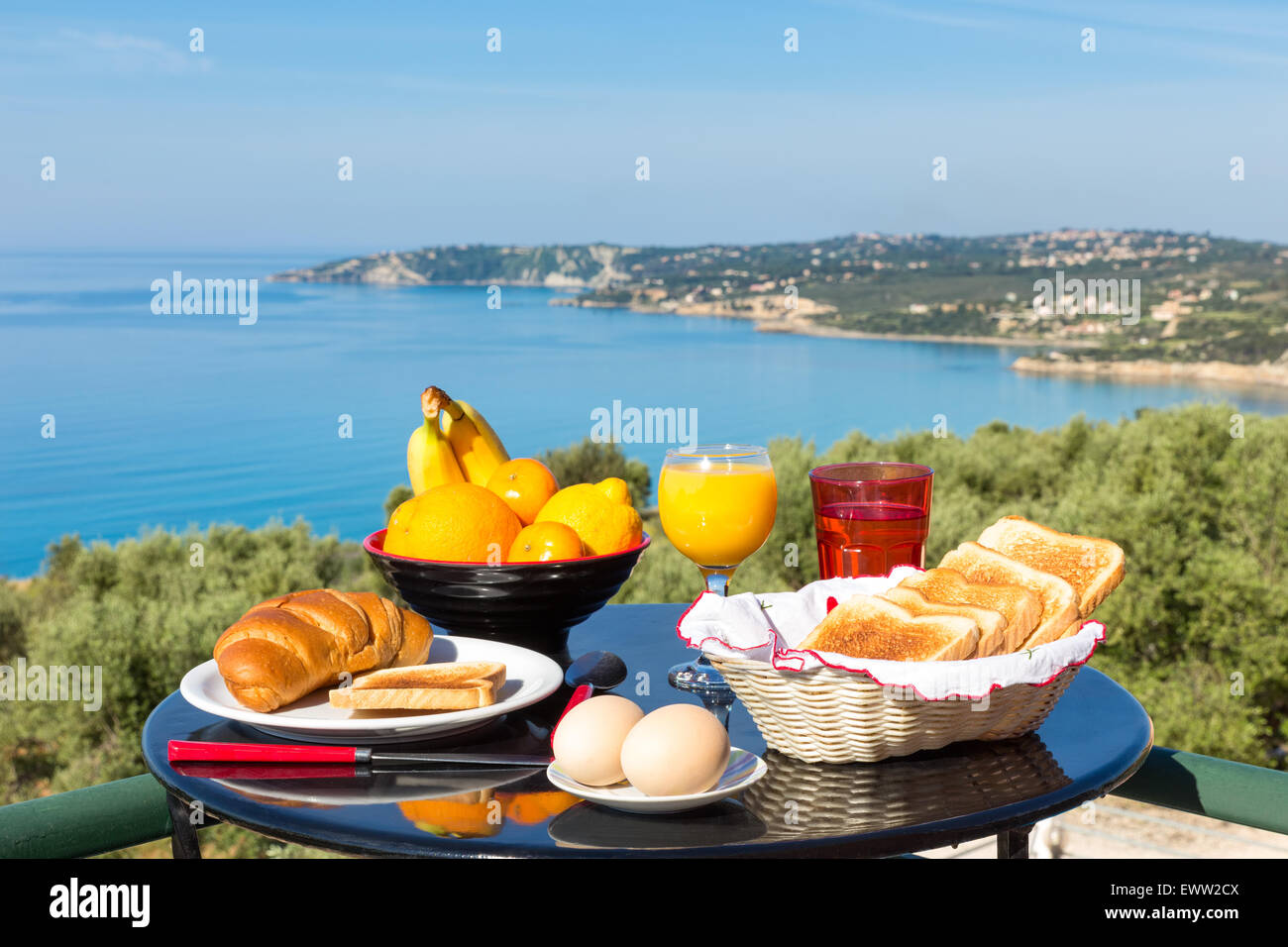 Table with food and drinks in front of sea on island Kefalonia in Greece Stock Photo