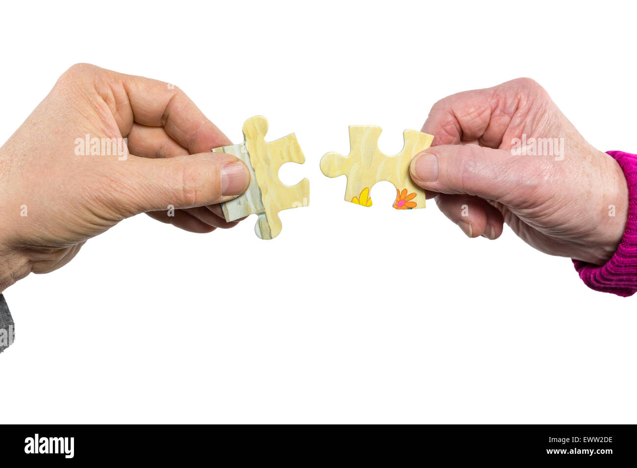 Two hands of man and woman joining uniting fitting puzzle pieces isolated on white background Stock Photo