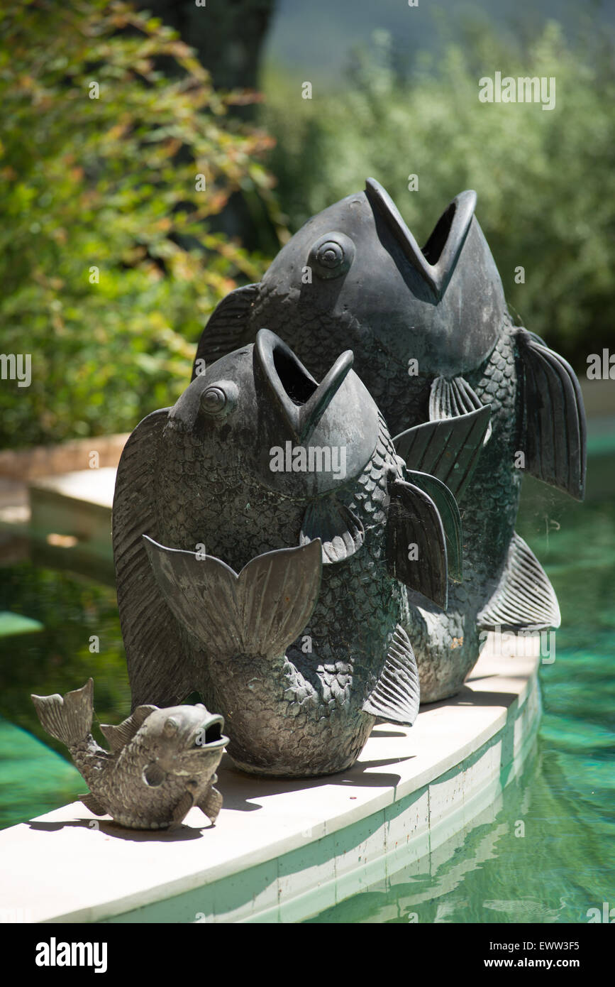 Bronze asian dancing fish statues at poolside Stock Photo