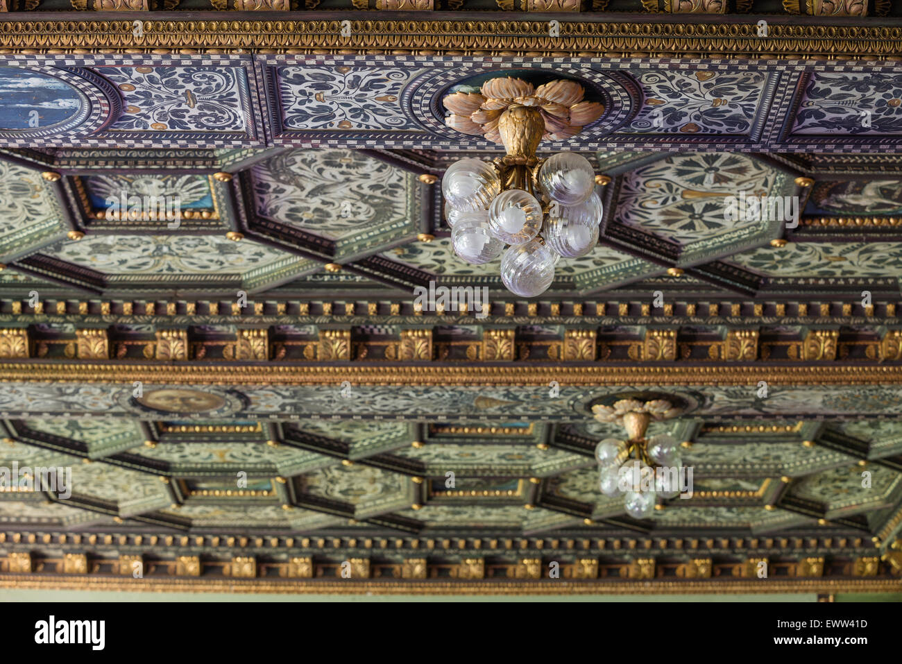 Glass bauble light fitting hung from hand painted gilt stucco coffered ceiling Stock Photo