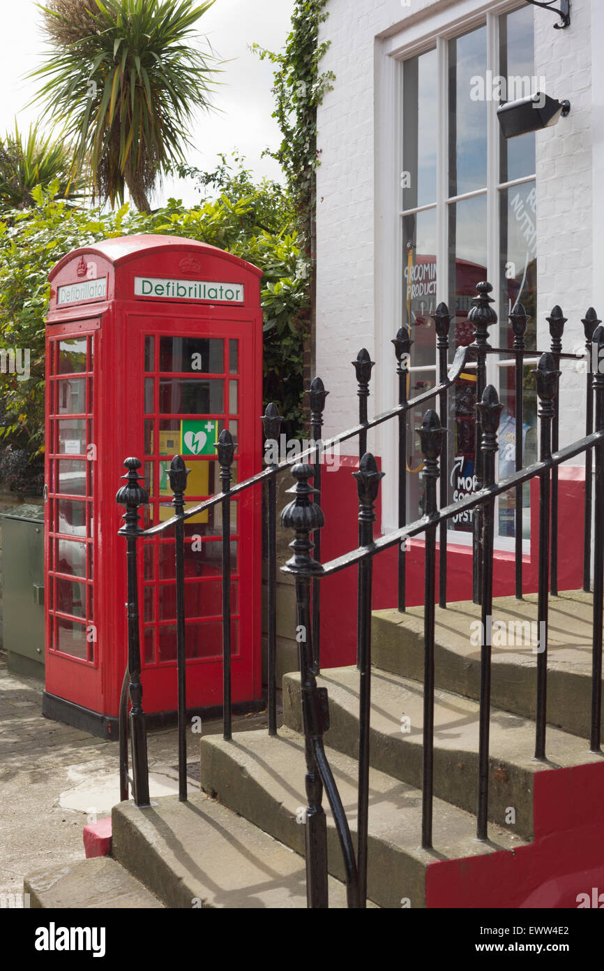 Historic Red phone box used to house a defibrillator for public use in case of emergency. Stock Photo