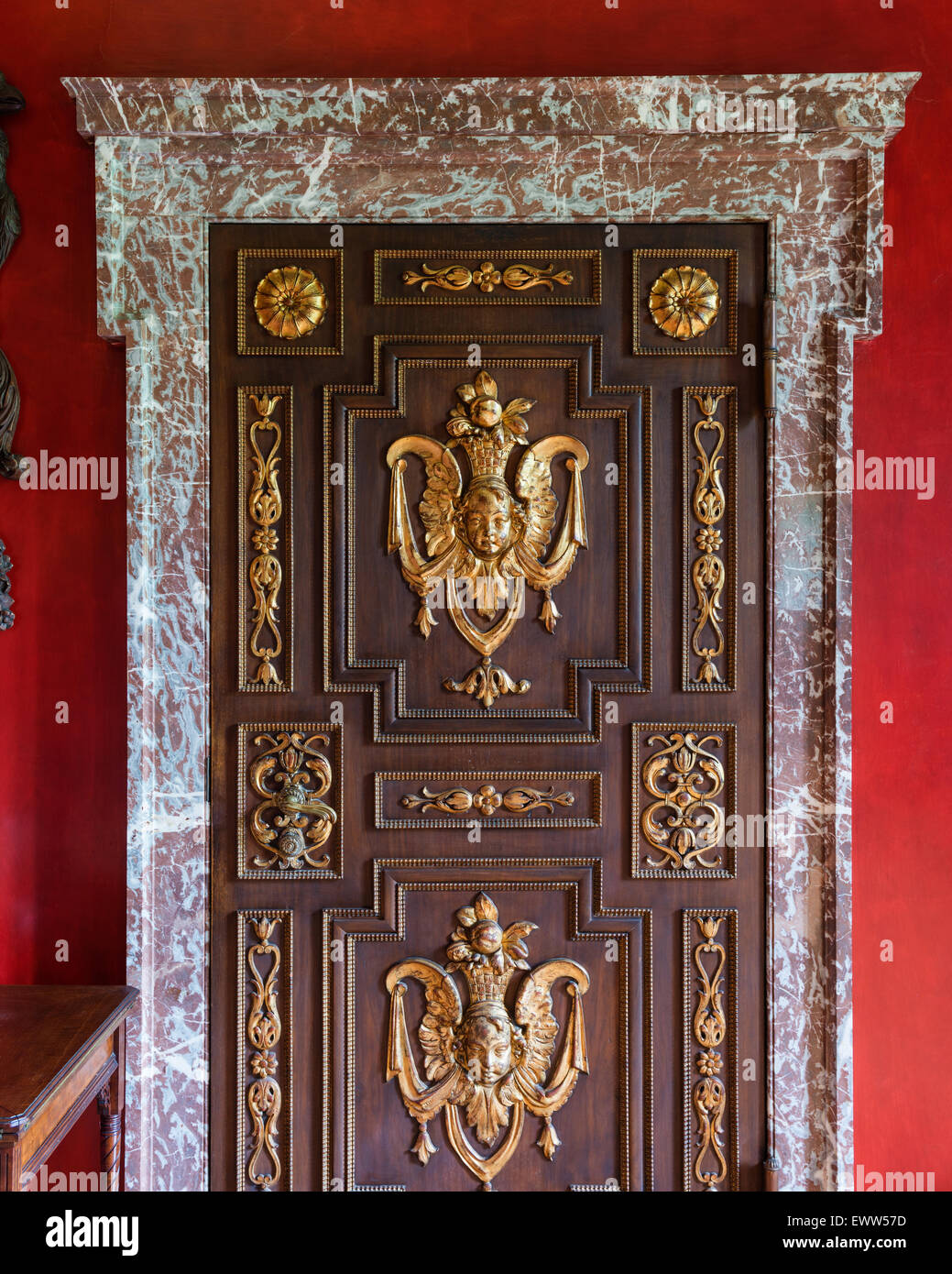 Gilt stucco mouldings on panelled door with marble frame Stock Photo