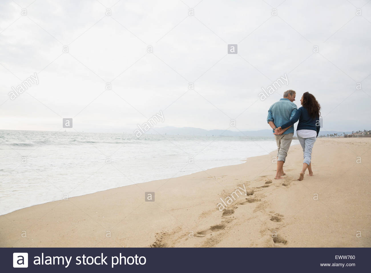 Affectionate couple holding hands walking on beach Stock Photo Alamy