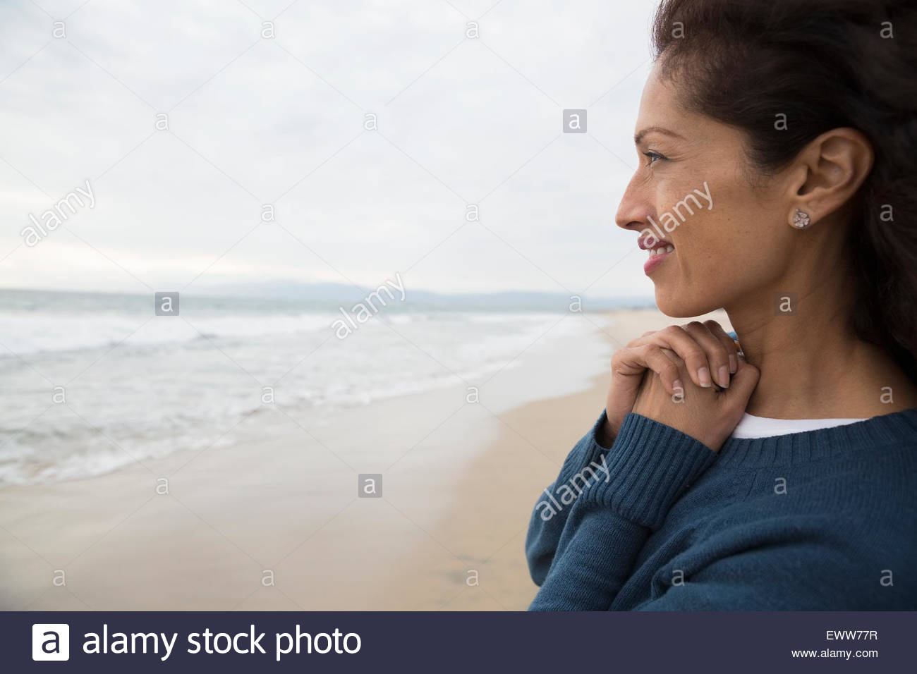 Serene woman looking at ocean view from beach Stock Photo