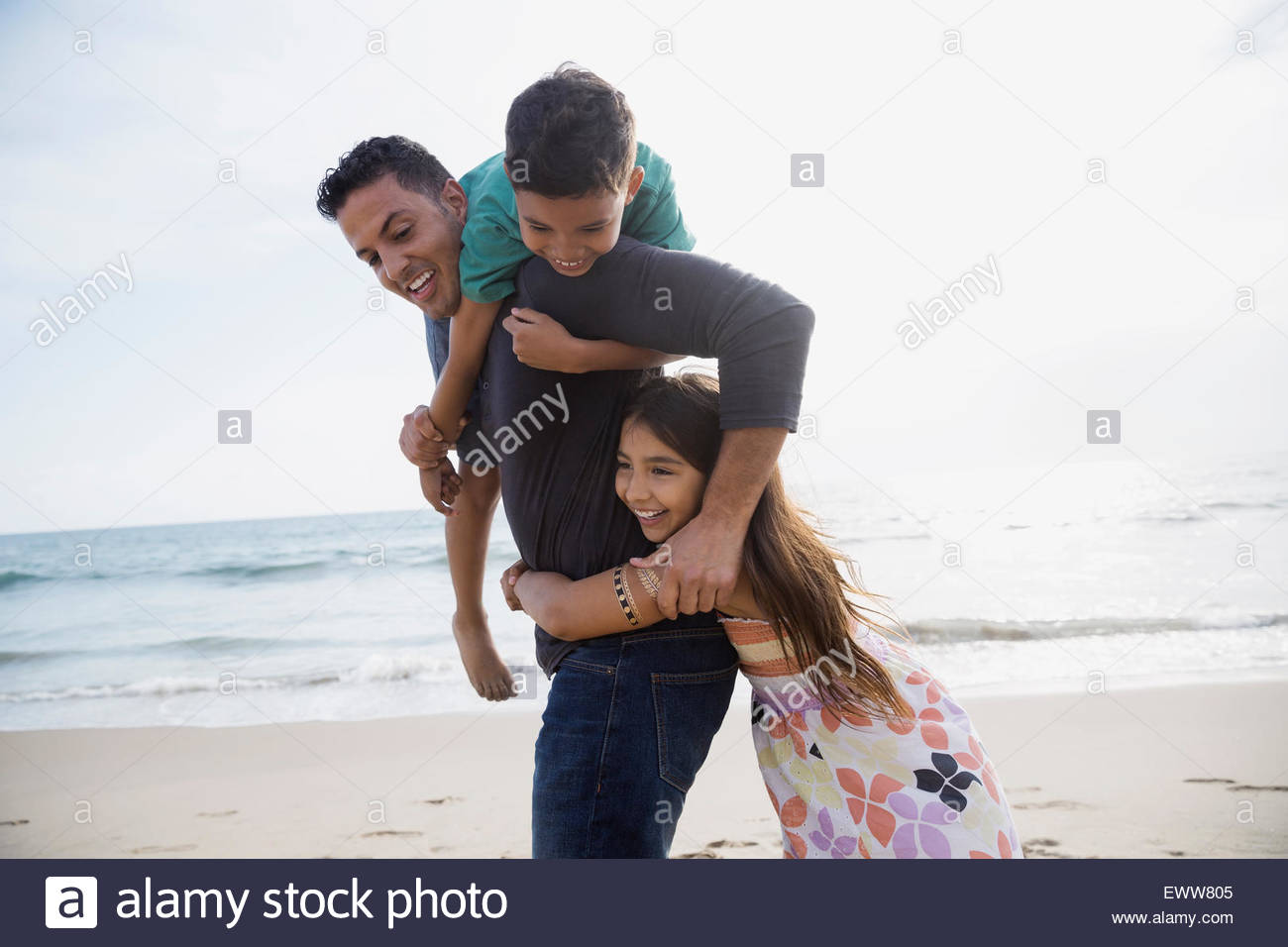 Playful family on sunny beach Stock Photo