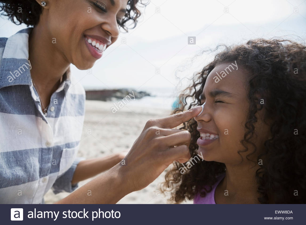 Mother applying sunscreen to daughter nose Stock Photo