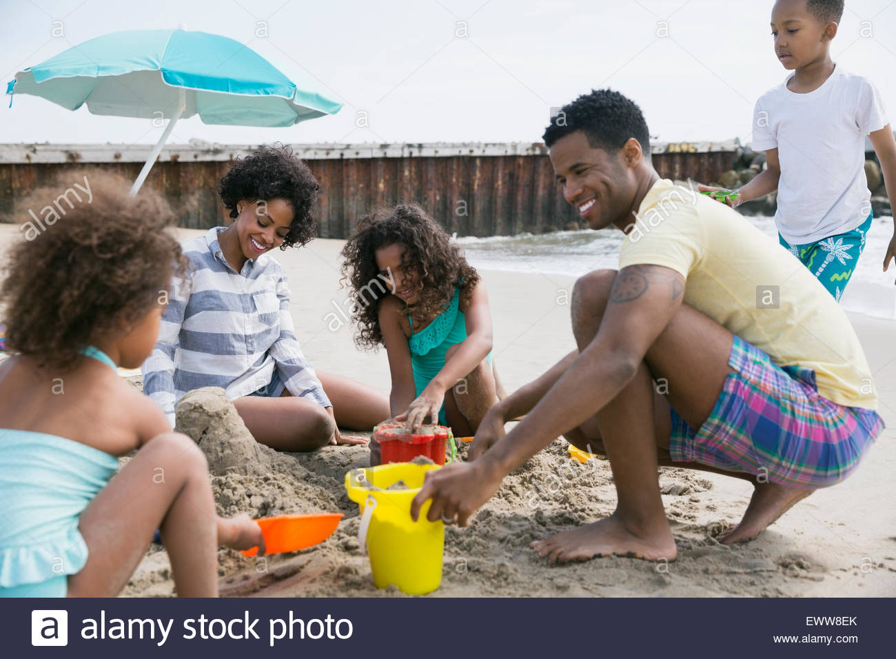 Family making sandcastle on beach Stock Photo