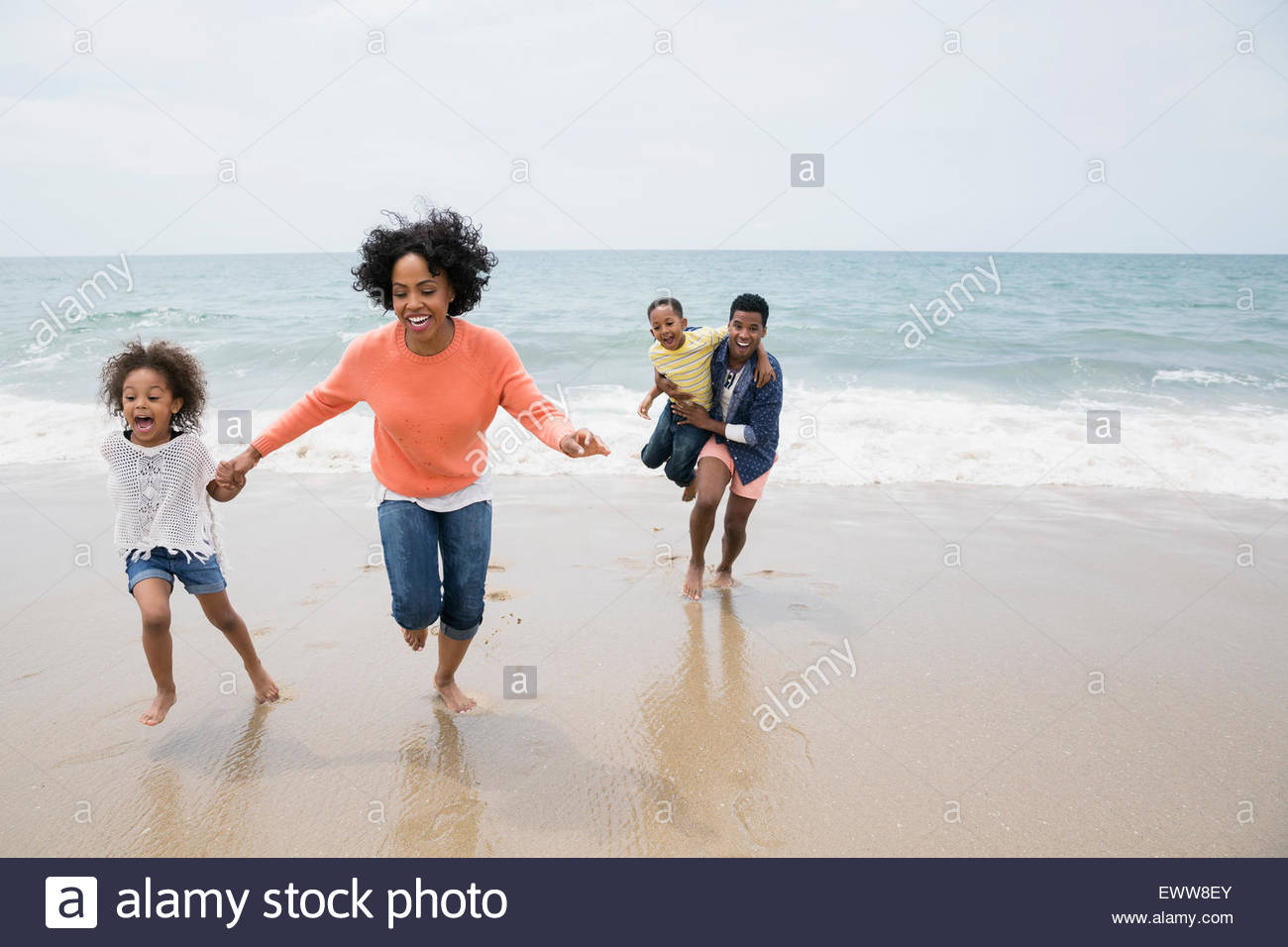 Happy family running on beach hi-res stock photography and images - Alamy