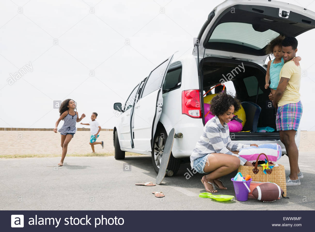 Family unloading van at beach Stock Photo