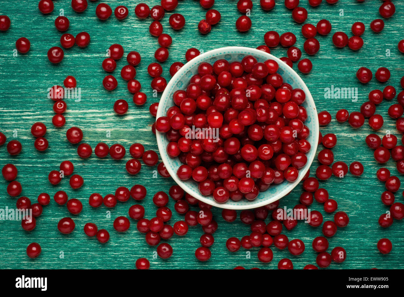 Ripe cherry in a vintage bowl on wooden background Stock Photo