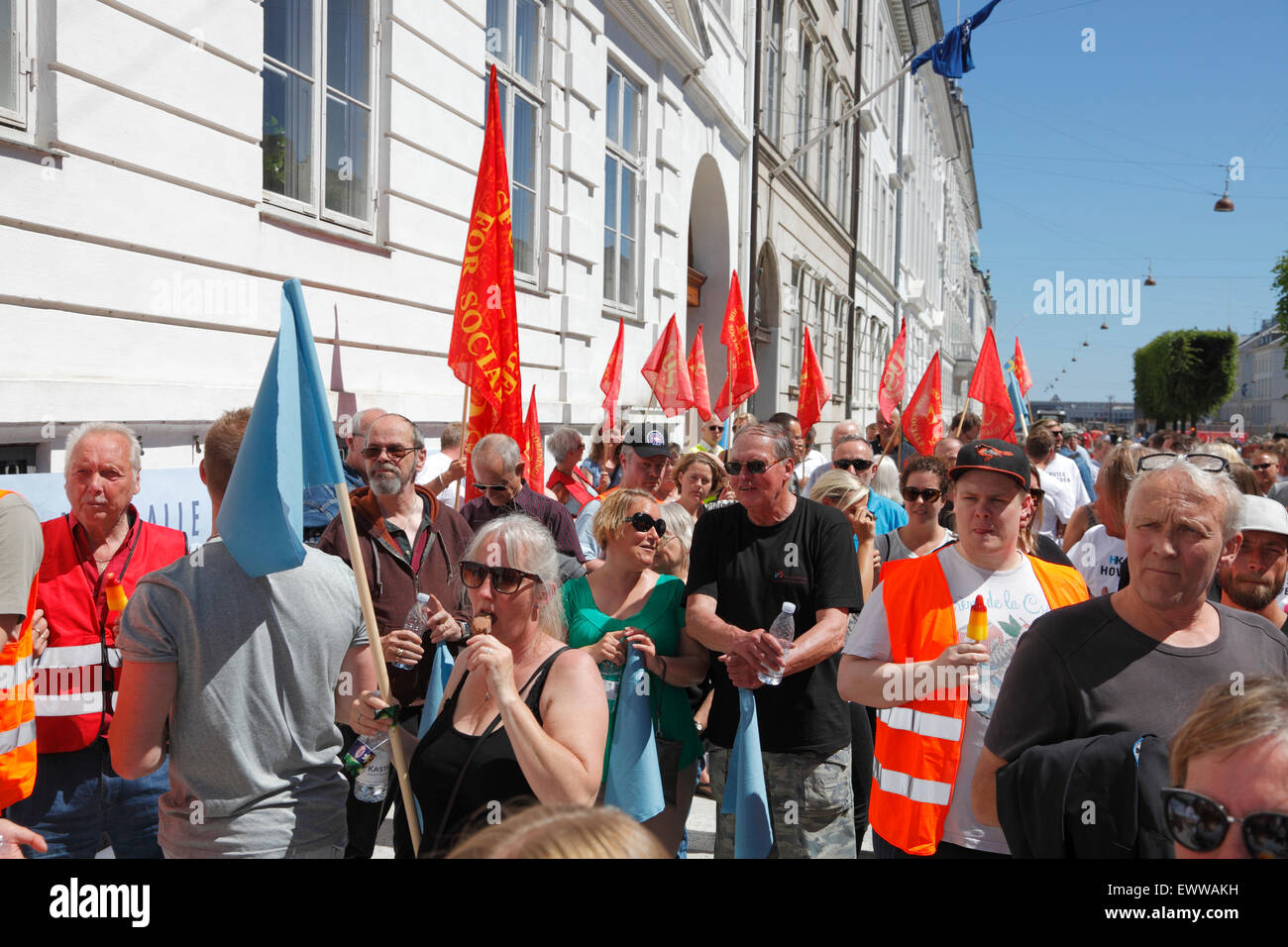 Copenhagen, Denmark. July 1, 2015. The Danish labour market model and the Danish Federation of Trade Unions (LO) won this afternoon in the Danish Labour Court in Copenhagen. Ryanair’s recently established base in Copenhagen is ruled subject to Danish labour laws and industrial actions can be taken by the unions. A large supporting crowd of supporters, members from other unions, etc. waiting outside the court building to hear the court ruling. The red flags and banners belong to the social education workers union. Credit:  Niels Quist/Alamy Live News Stock Photo