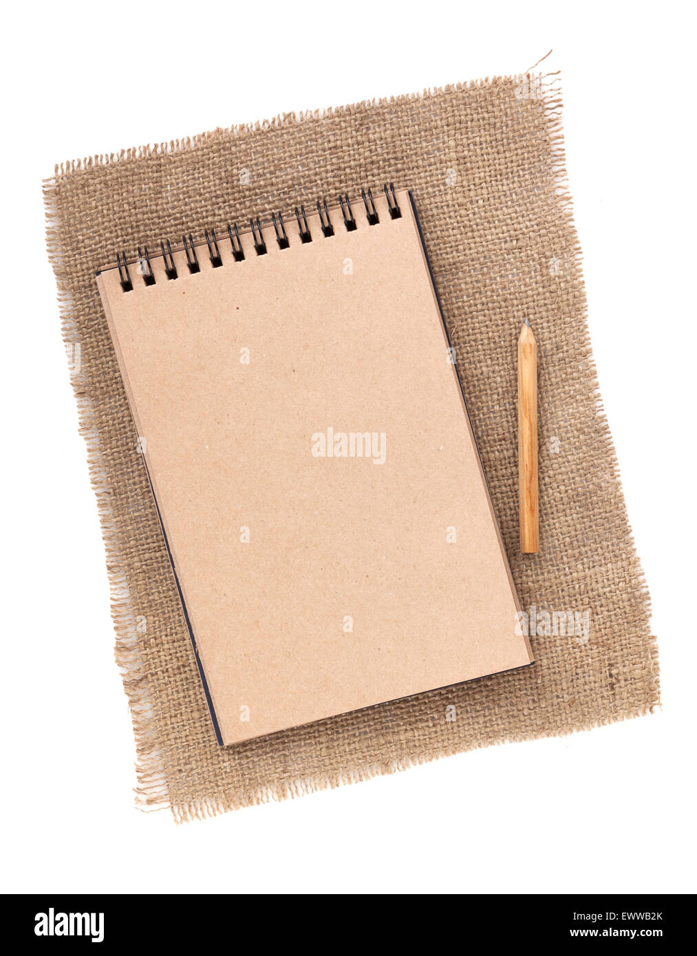 Brown paper notepad with pencil over burlap. Isolated on white