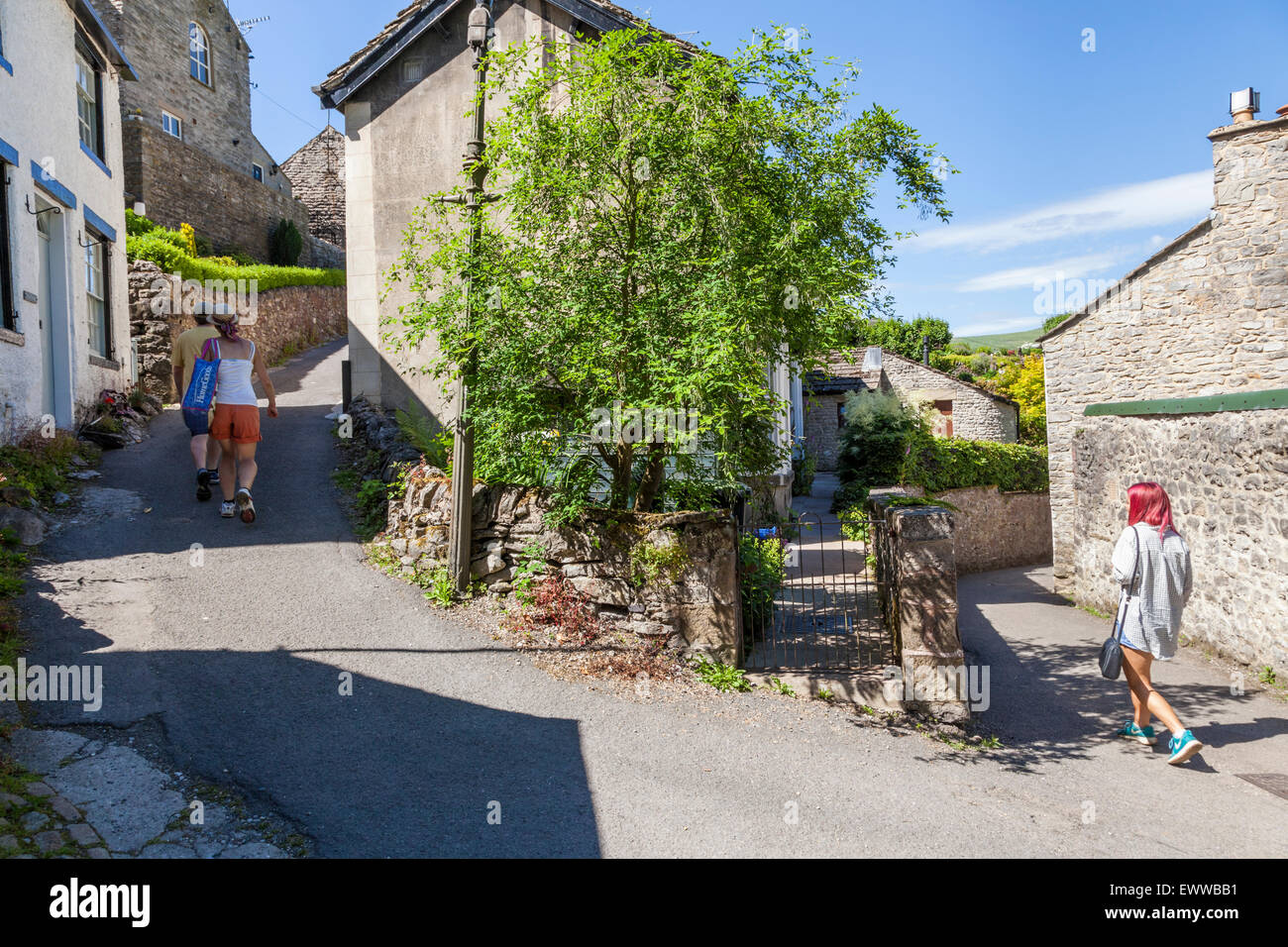 People walking along an English village lane in Summer. Castleton