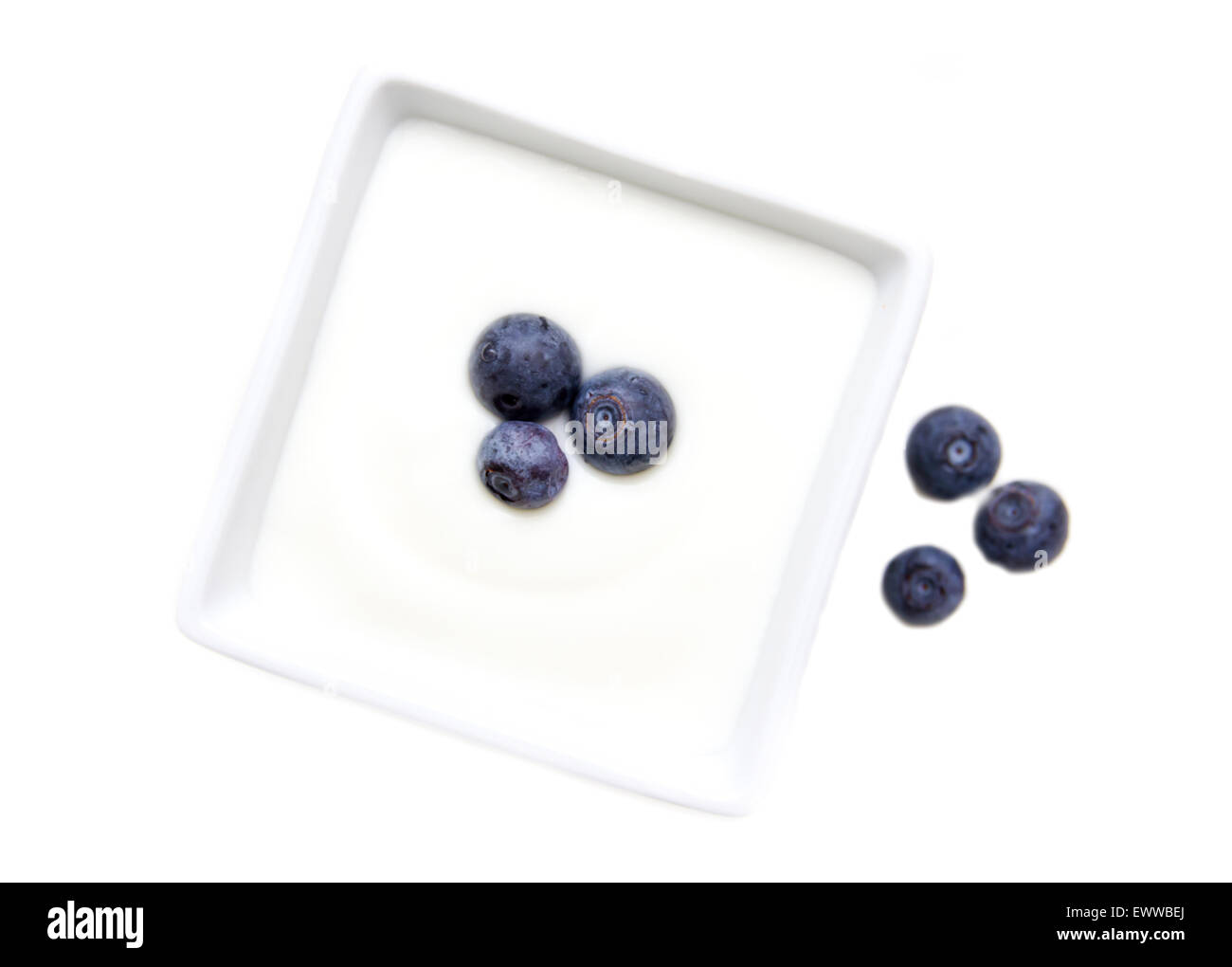 Yogurt with blueberries on square bowl on a white background seen from above Stock Photo