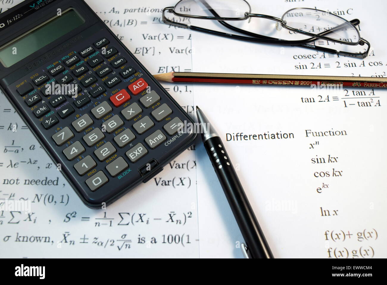 Eye Glasses, pen and pencil over the Formula with calculator Stock