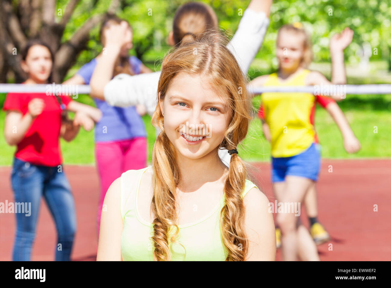 Portrait of teen girl with friends play volleyball Stock Photo