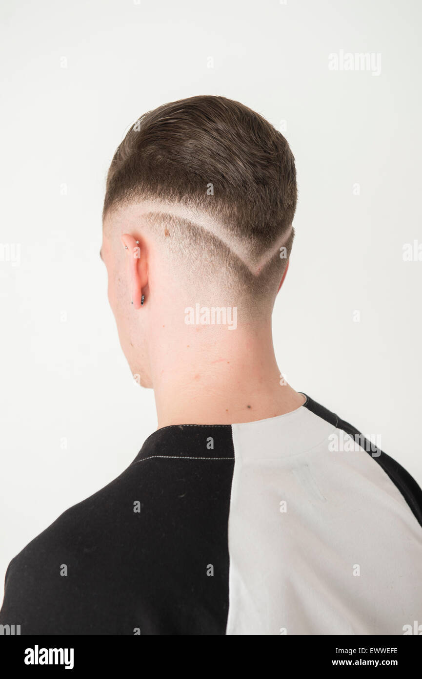 A head and shoulders back rear portrait of a young man male person with a  radical razor cut sharp fashionable modern hair style UK Stock Photo - Alamy