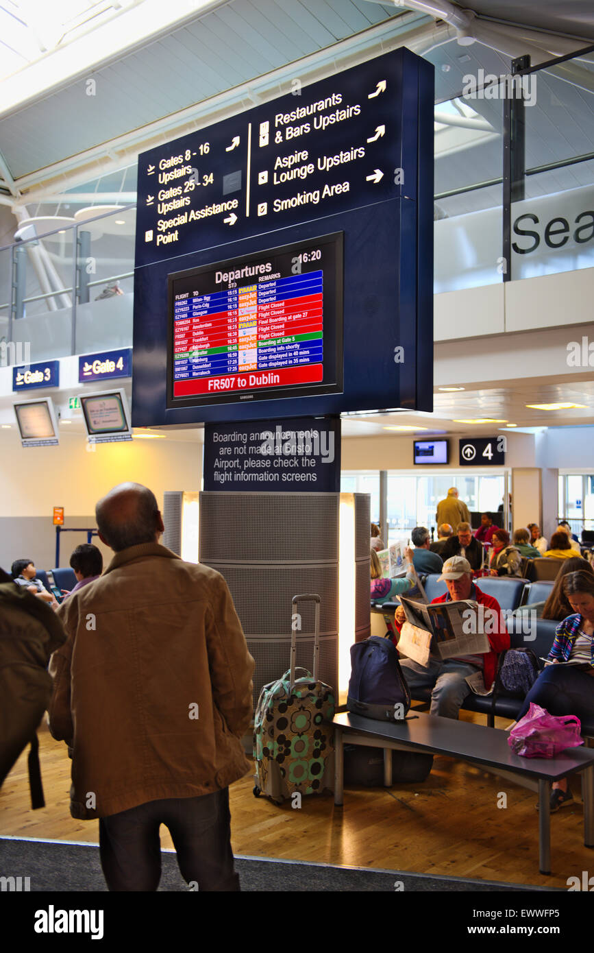 Man looking at airplane departure flight status and direction information display Stock Photo