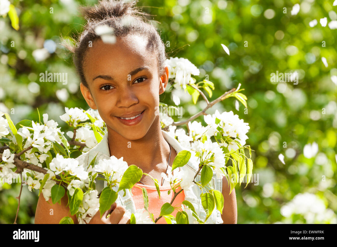 African teenager girl with flowers on pear tree Stock Photo