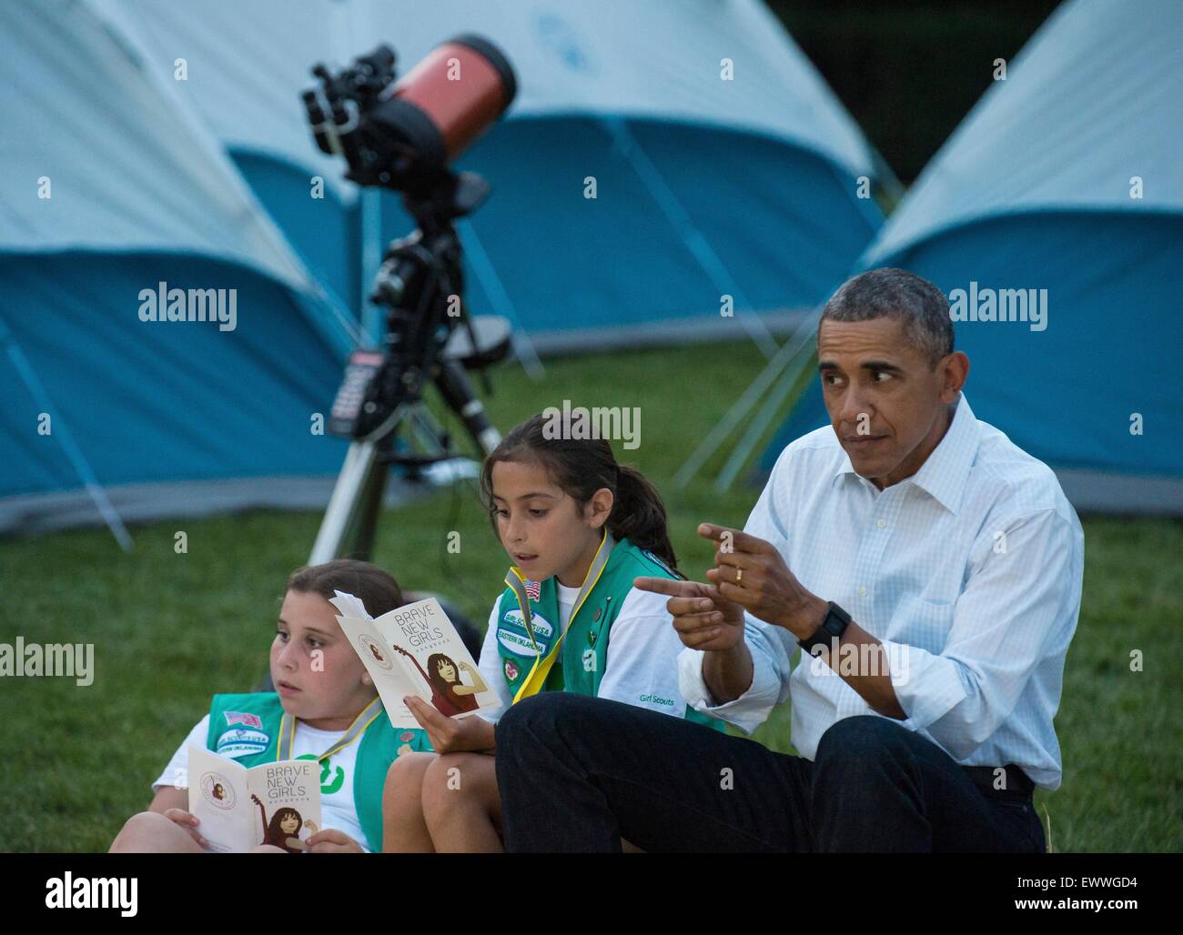 U.S. President Barack Obama jokes with Girl Scouts during the first-ever White House Campout with fifty fourth-grade girls as part of the Let's Move! Outside initiative on the South Lawn of the White House June 30, 2015 in Washington, DC. In addition to the campout the girls enjoyed stargazing activity with scientists and astronaut Cady Coleman. Stock Photo