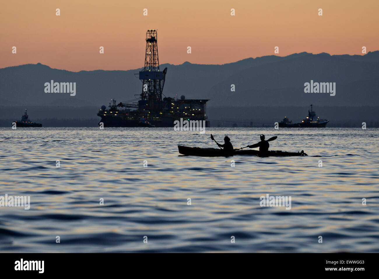Protesters in kayaks known as kayaktivists attempt to block the deep arctic oil exploration ship Noble Discover as it transits the Puget Sound after departing June 30, 2015 from the Port of Everett, Washington. The Coast Guard enforced a 500-yard safety zone around the vessel as activists continued to try and block the ship. Stock Photo