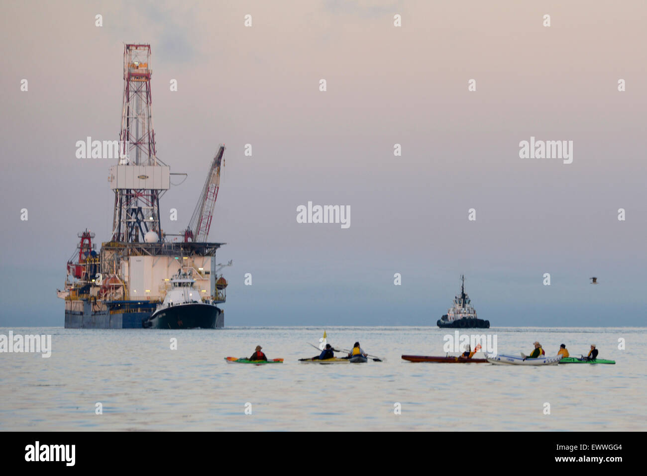 Protesters in kayaks known as kayaktivists attempt to block the deep arctic oil exploration ship Noble Discover as it transits the Puget Sound after departing June 30, 2015 from the Port of Everett, Washington. The Coast Guard enforced a 500-yard safety zone around the vessel as activists continued to try and block the ship. Stock Photo