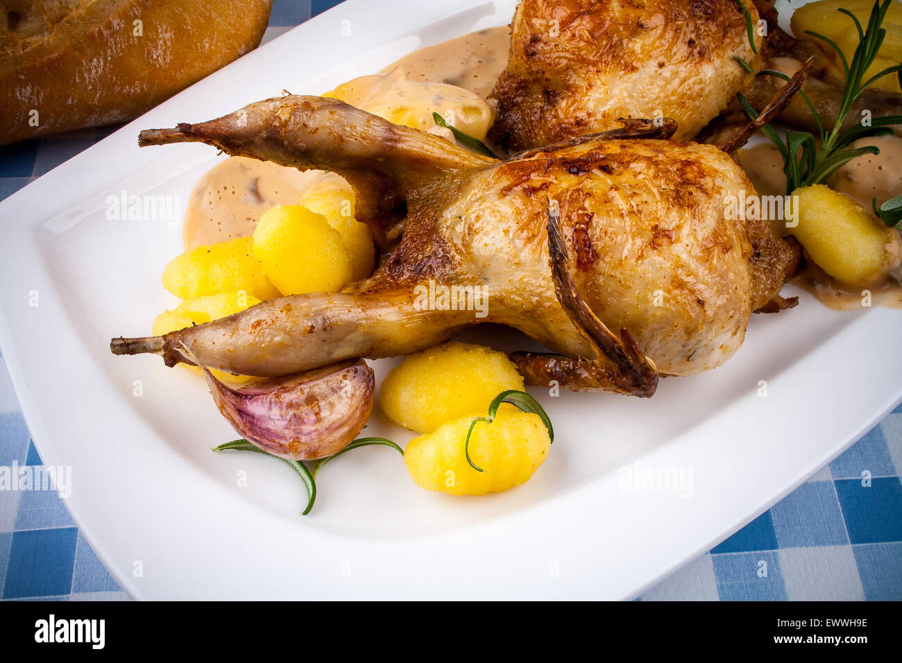 Fried quail with gravy, gnocchi, rosemary, bread and sauces Stock Photo