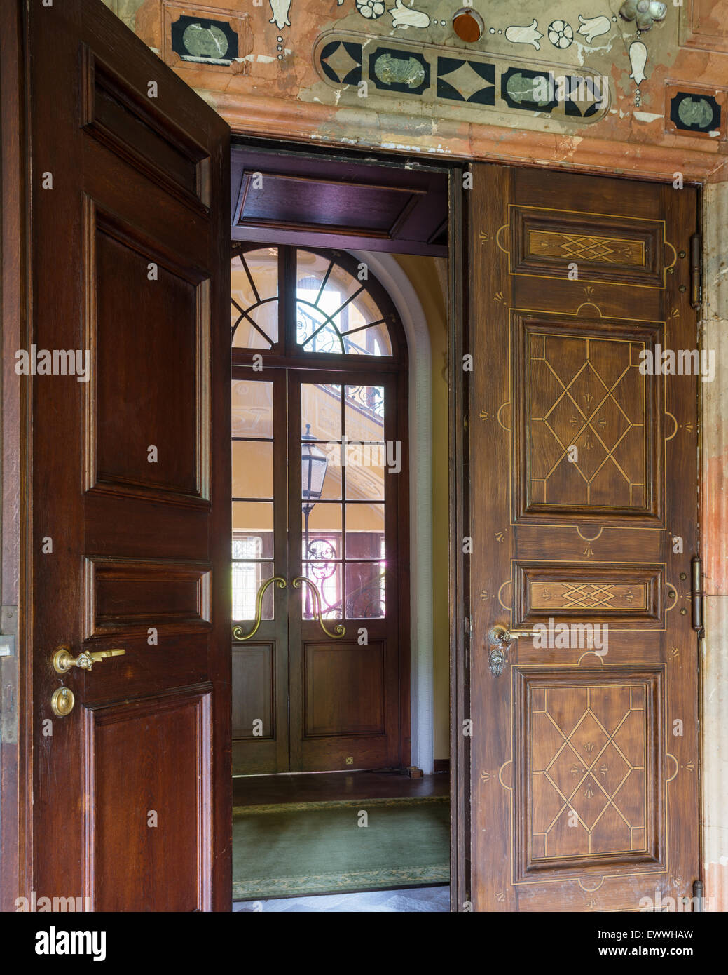 View through open inlaid door to glass panelled door with fanlight Stock Photo