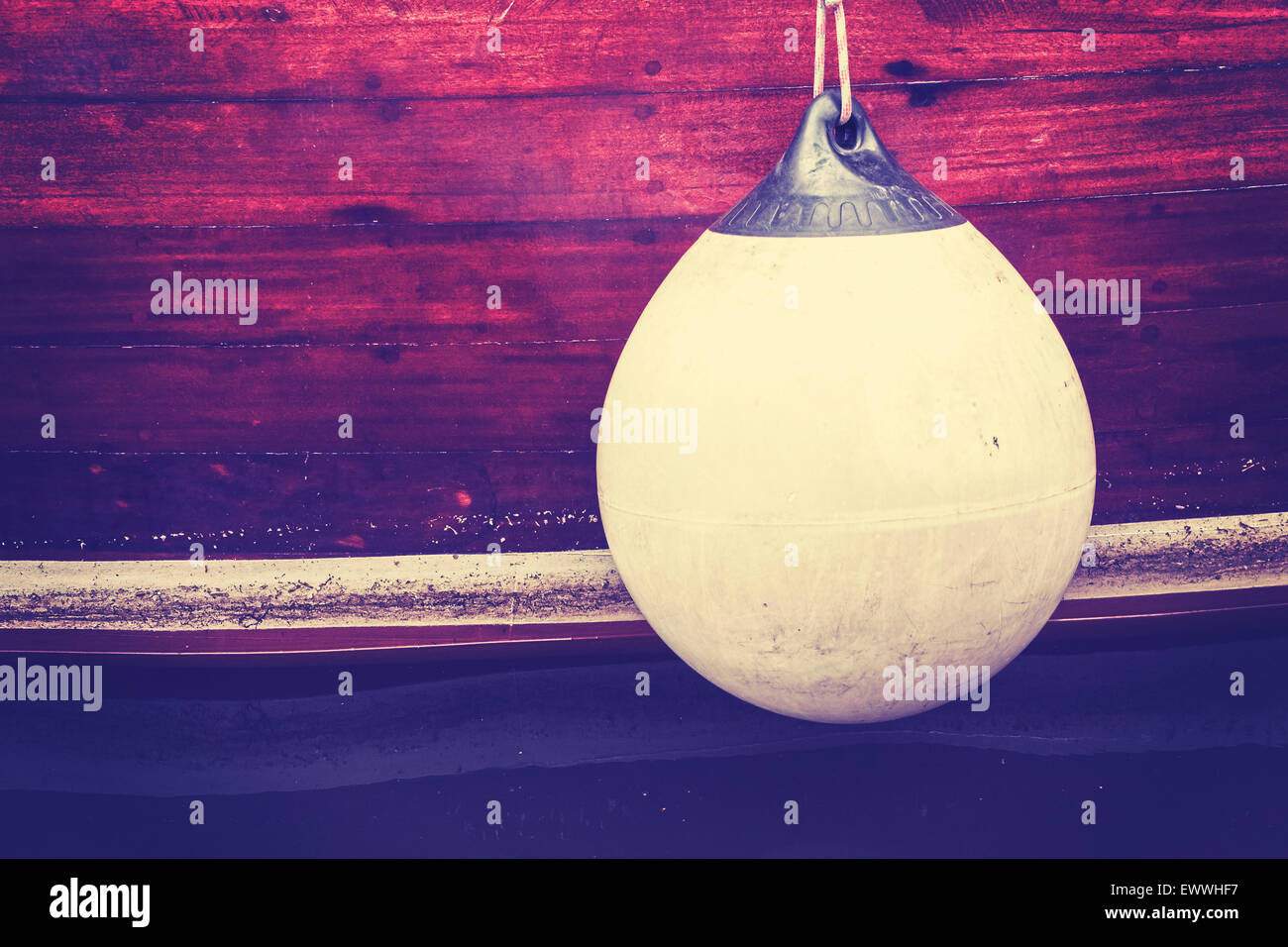 Rubber buoy for protecting moored yachts in marina, vintage toned concept photo. Stock Photo
