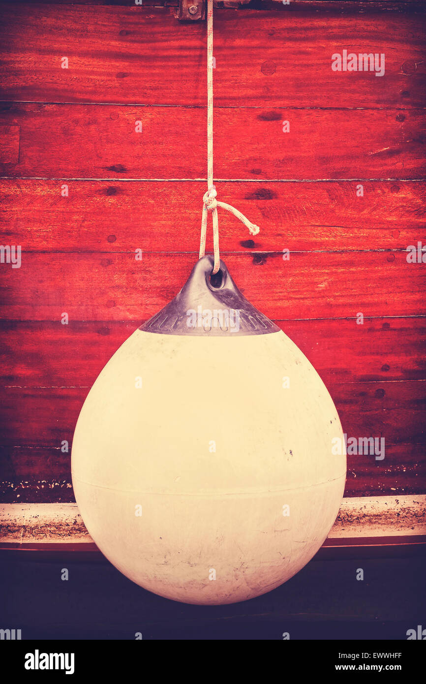 Rubber buoy for protecting moored yachts in marina, vintage toned concept photo. Stock Photo