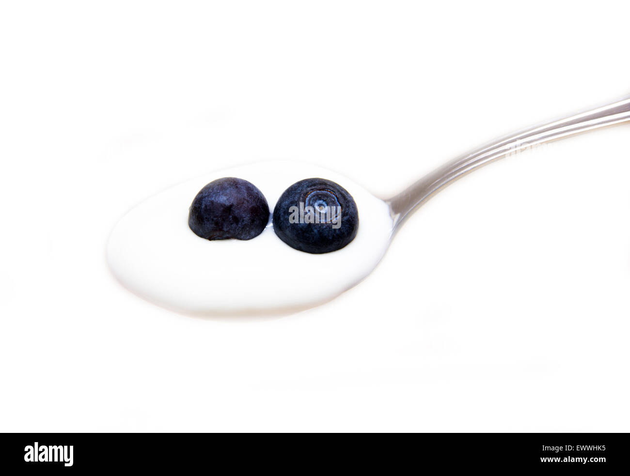 Spoon with yogurt and blueberries on white background Stock Photo