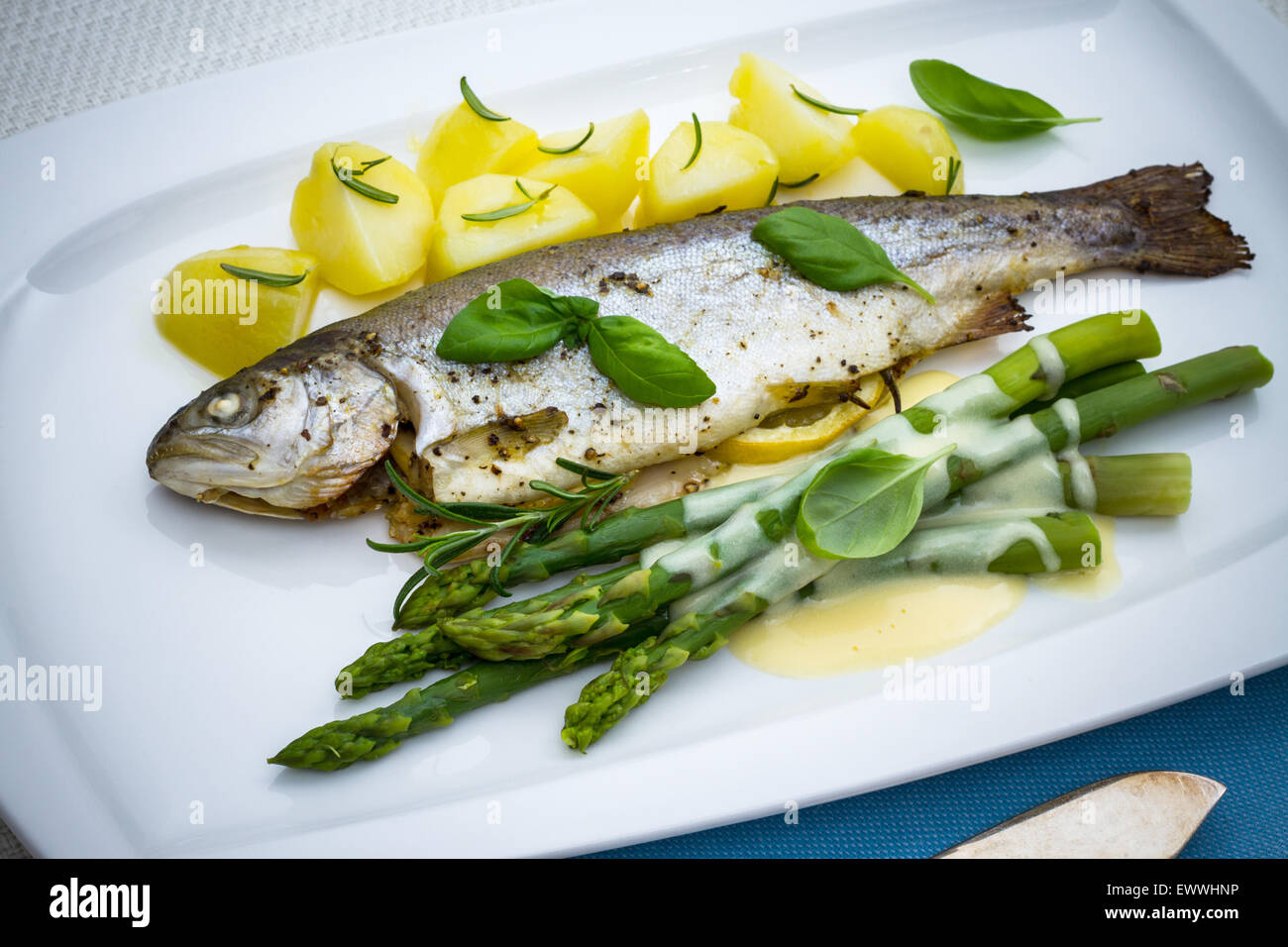 Grilled trout with green asparagus and rosemary potatoes, top view
