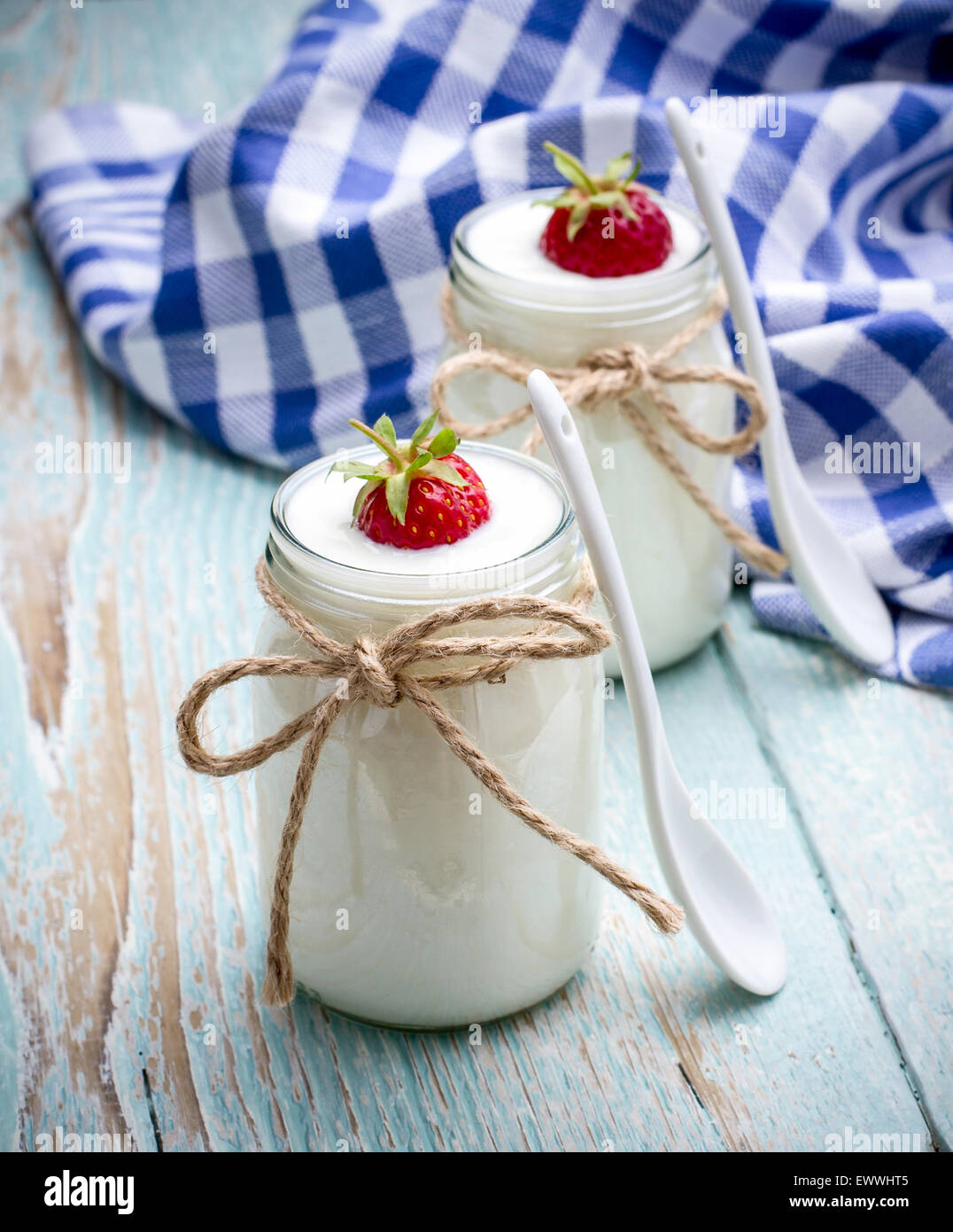 Two glass yogurt with strawberries on wooden, ceramics spoon Stock Photo