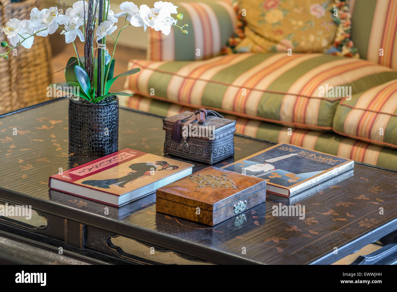 Asian coffee table displaying Japanese art books and white orchid Stock Photo