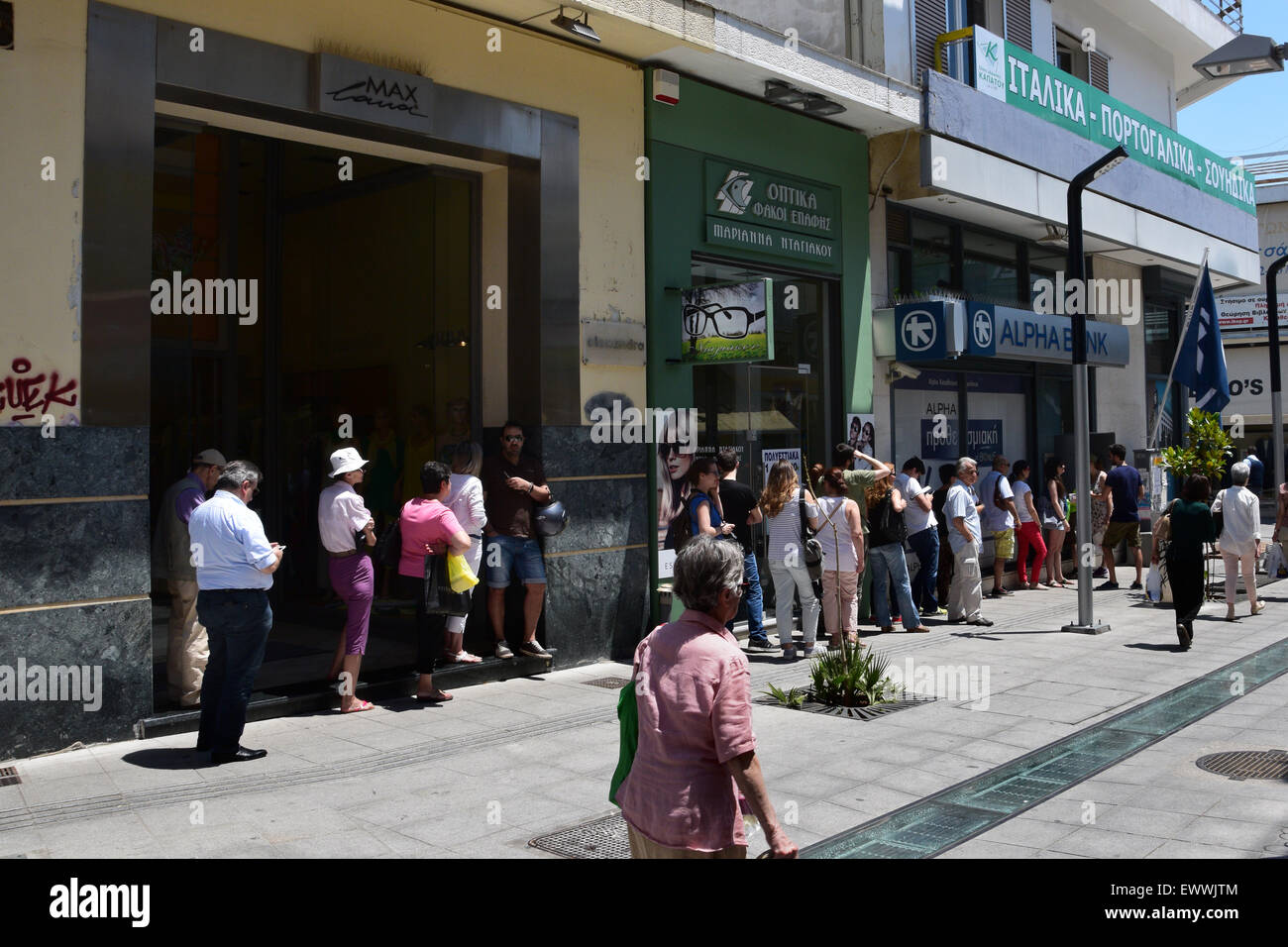 Long queue of people wait for money from ATM cashpoint. Banks are closed after bank run and capital controls are implemented. Stock Photo