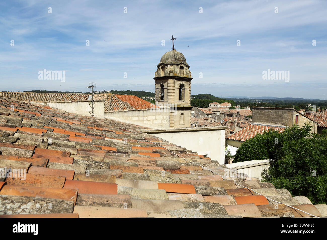 Terracotta roof tiles in Sommieres, France. The tower of the church of Saint Pons stands in the background. Stock Photo