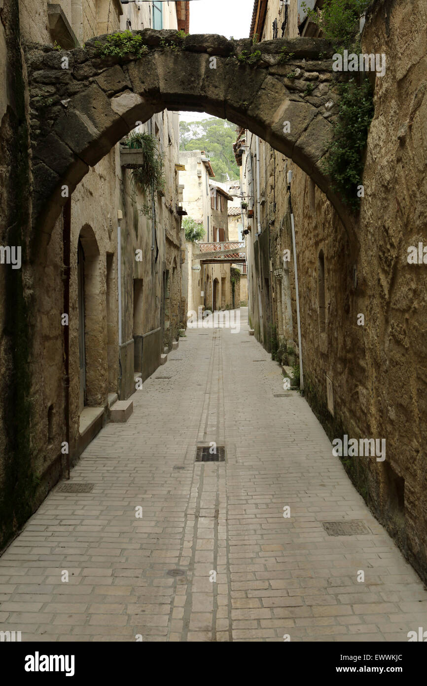 An alley in Sommieres, France. The narrow streets date from the Middles Ages and provide shade from the sun. Stock Photo