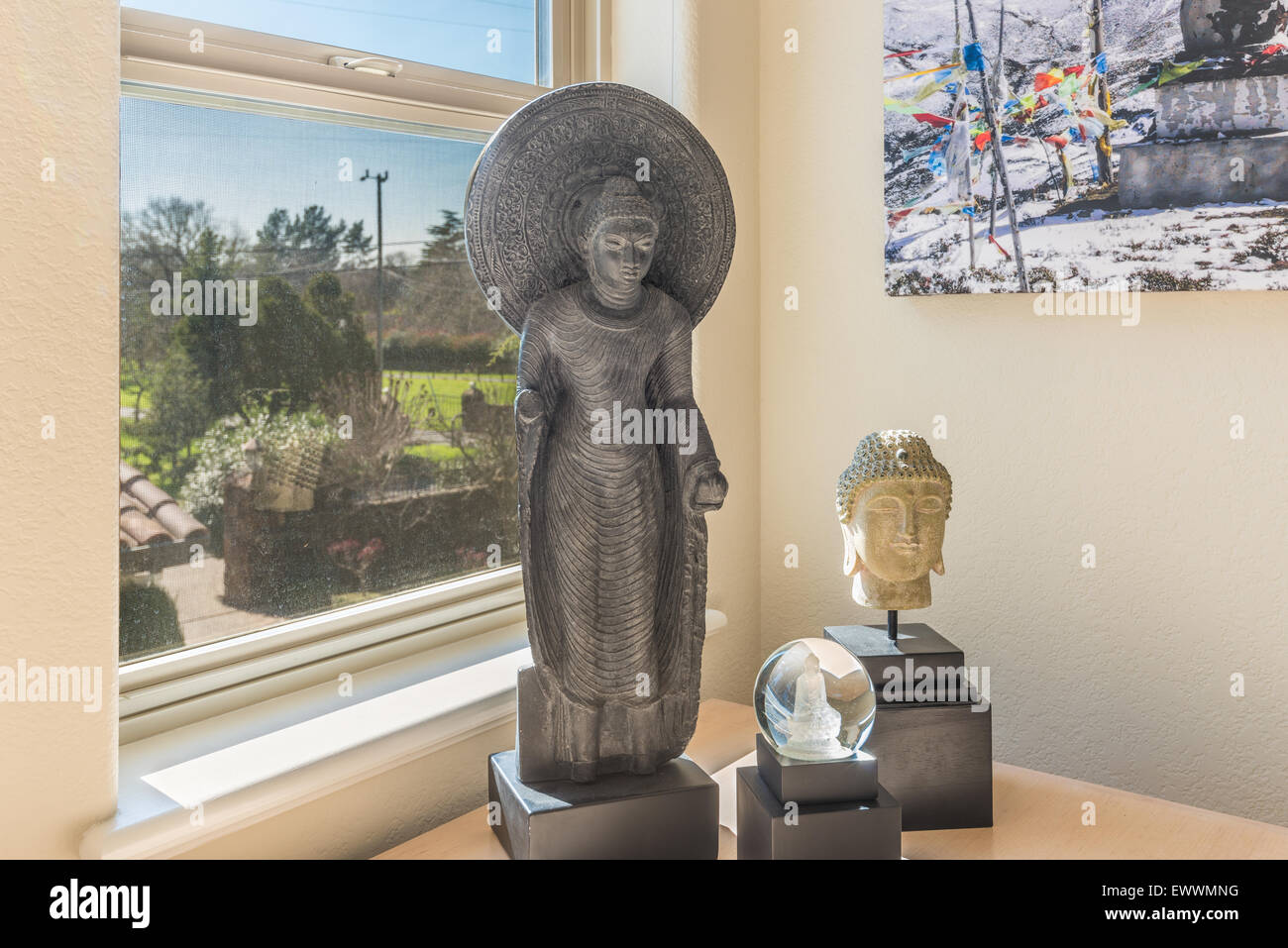 Buddhist figures backlit by window in Sonoma, California Stock Photo