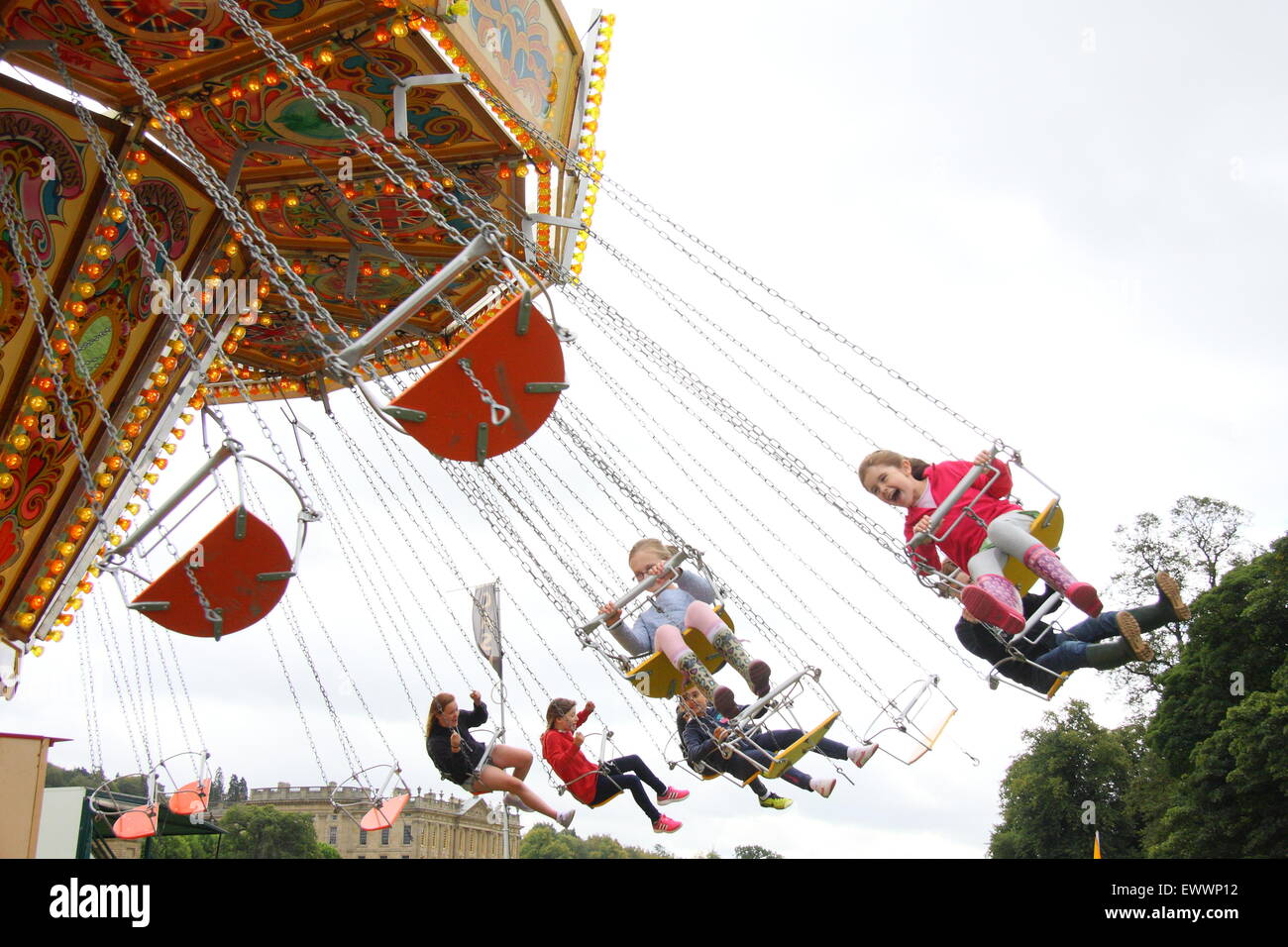 Children on a chain swing ride at Chatsworth Country Fair, Derbyshire England UK Stock Photo