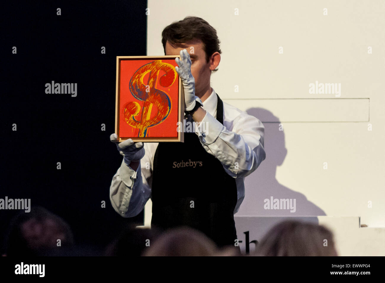 London, UK. 1 July 2015. A Sotheby's technician shows Andy Warhol's "Dollar  Sign" which sold for a hammer price of £420k, above estimate, at Sotheby's  Contemporary Art evening auction. The night's total