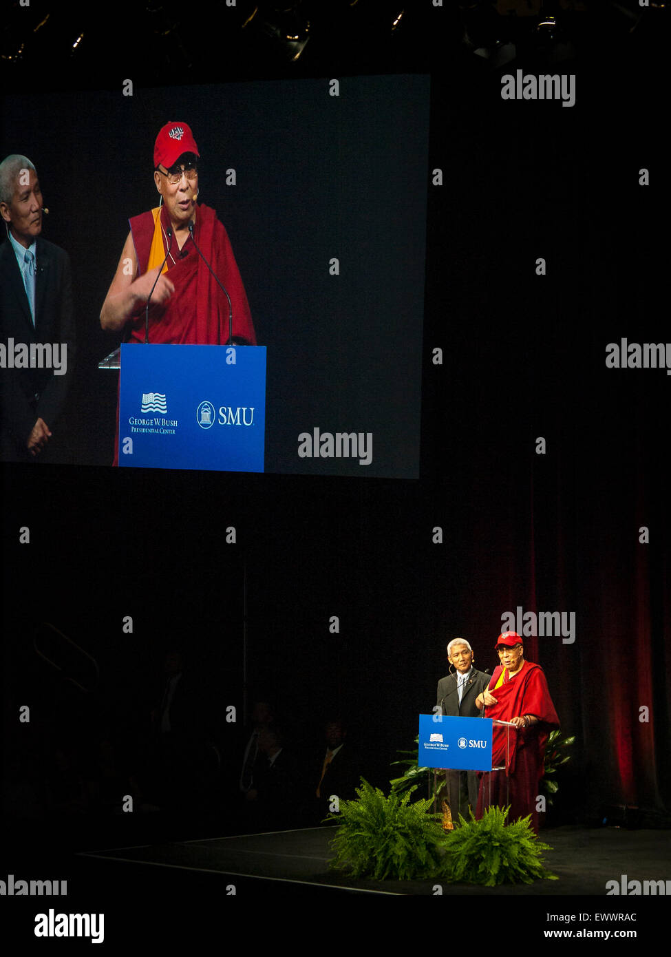 Dallas, Texas, USA. 1st July, 2015. The Dalai Lama speaks at the Moody Coliseum before 5200 people alongside is his translator and he wears a SMU cap. Credit:  J. G. Domke/Alamy Live News Stock Photo