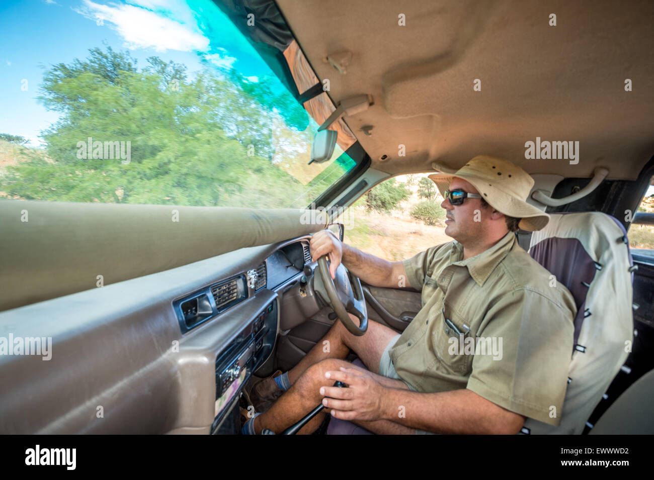 Namibia - Man driving car through African landscape. Stock Photo
