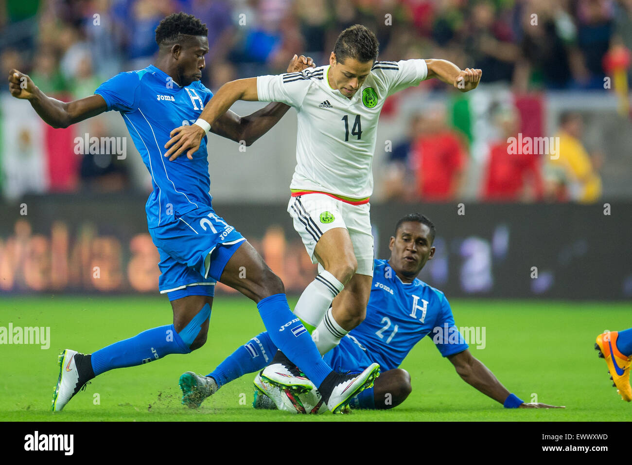 Houston, TX, USA. 1st July, 2015. Mexico forward Javier Hernandez (14) gets fouled by Honduras defender Johnny Palacios (23) and Honduras defender Brayan Beckeles (21) during the 1st half of an international soccer match between Honduras and Mexico at NRG Stadium in Houston, TX. Trask Smith/CSM/Alamy Live News Stock Photo