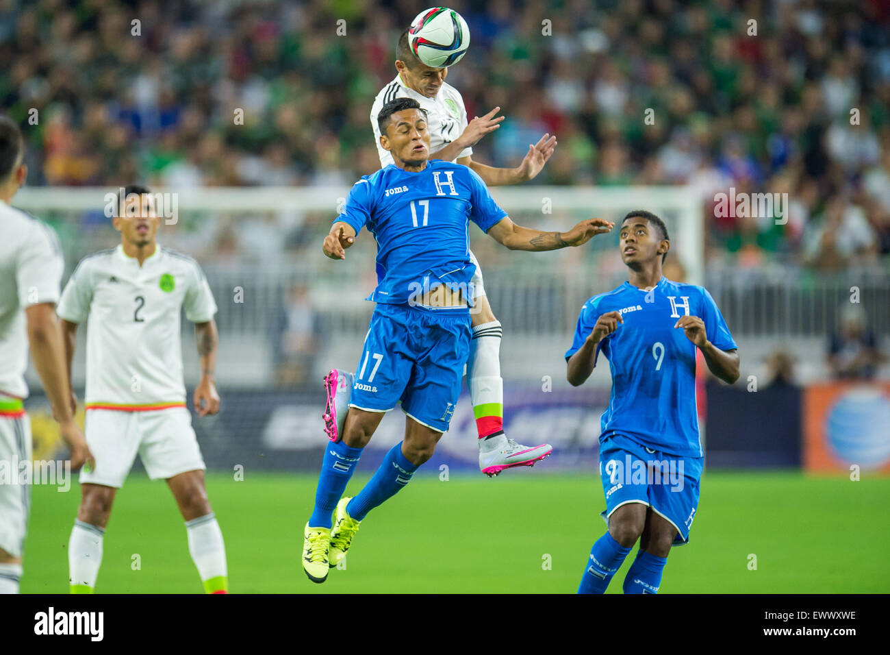 Houston, TX, USA. 1st July, 2015. Honduras midfielder Andy Najar (17) and Mexico defender Paul Aguilar (22) battle for a header during the 1st half of an international soccer match between Honduras and Mexico at NRG Stadium in Houston, TX. Trask Smith/CSM/Alamy Live News Stock Photo