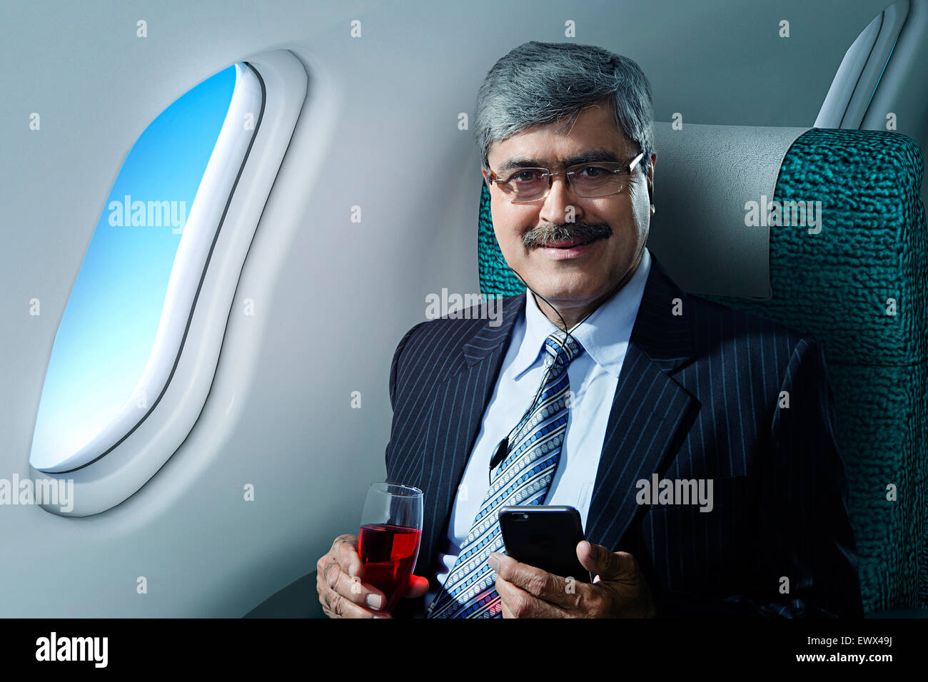 1 Business Man Sitting Aeroplane Cell phone hearing Music Stock Photo