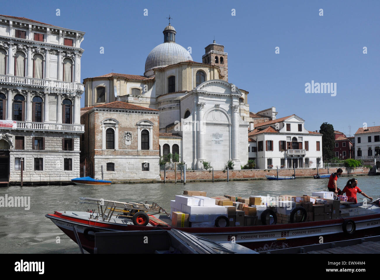 Italy Venice Canale Grande - Cannaregio region - work boat being unloaded on Riva di Biasio - opposite San Geremia - sunlight Stock Photo