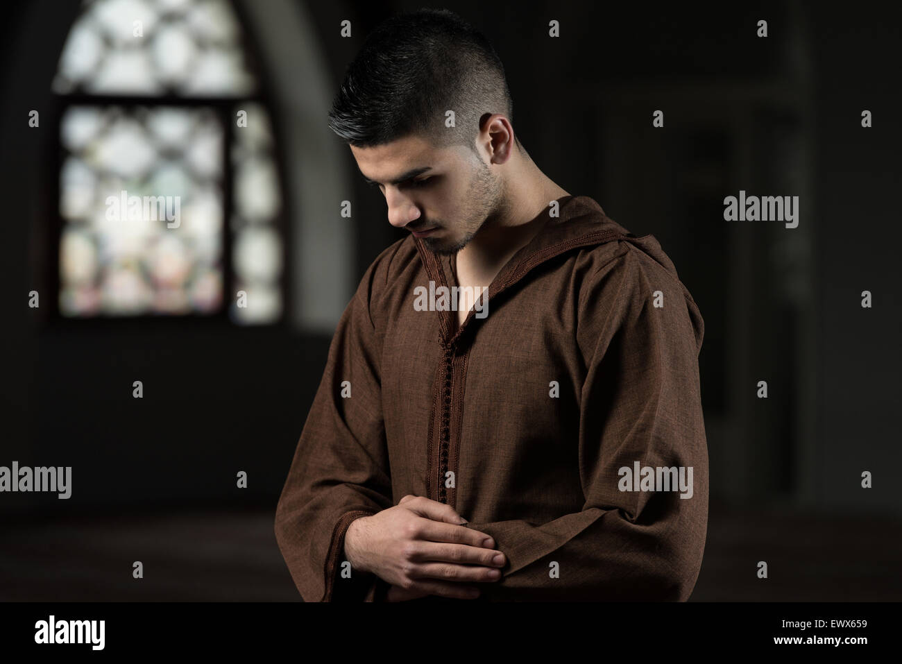 Young Muslim Man Making Traditional Prayer To God While Wearing A Traditional Cap Djellaba Stock Photo